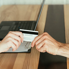 A Person Handing a Debit Card to Another One